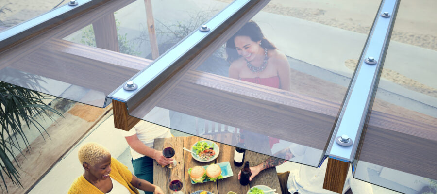Close up of Clear EZ Glaze™ Polycarbonate system installed on a pergola above a Group Of People Dining