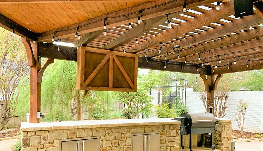 Weather Resistant Outdoor TV Enclosure installed about outdoor kitchen on a pergola